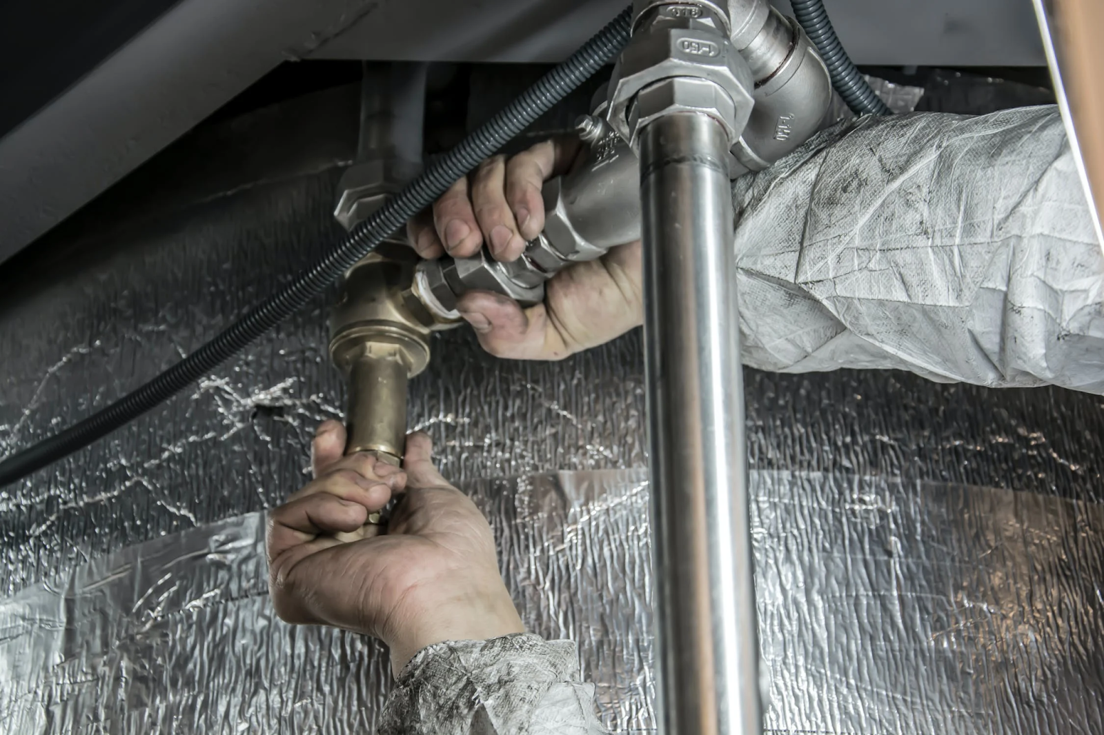 technician trying to stop water leak in a home