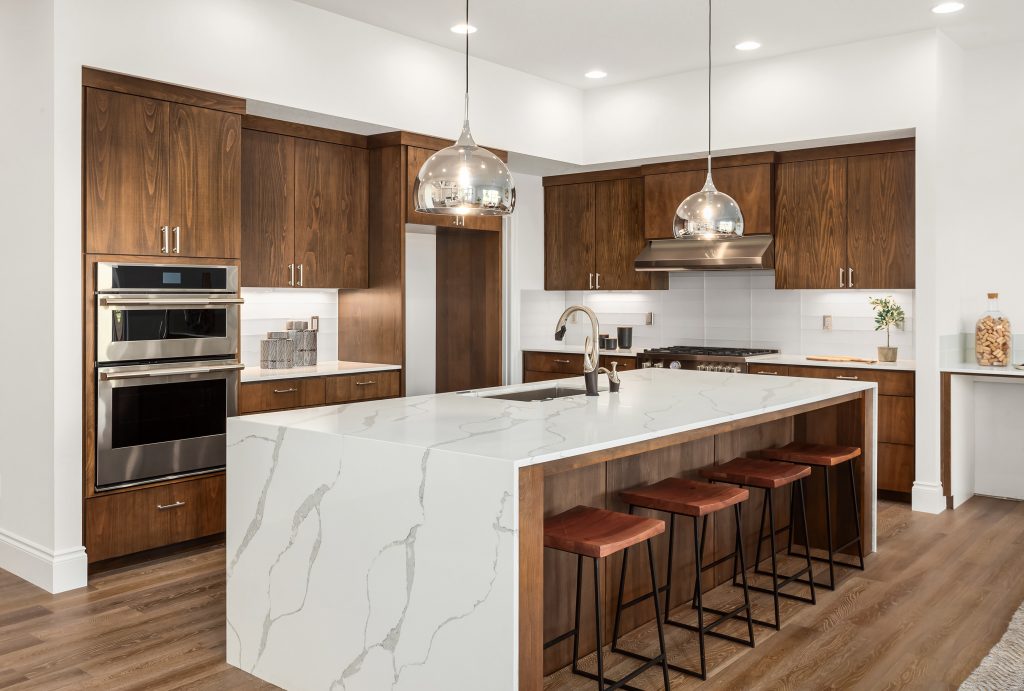 remodeled closed off kitchen with marble countertops, dark oak wood flooring, and dark oak cabinets