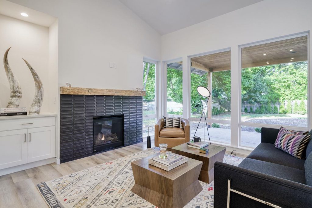 Living room remodel featuring build-in cabinets, light wood floors, and large bay windows